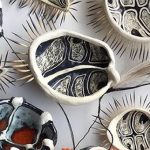 Image: Penny Evans, Estuarine Creatures with Gawu 2018, white earthenware with sgraffito and glazes, echidna quills, emu feathers, plastic flowers, raffia.
